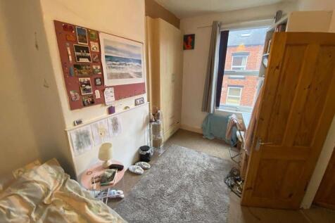 A cozy bedroom featuring a single bed, a spacio...