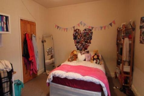 A cozy master bedroom featuring a large bed dec...