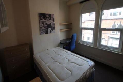 A tidy and well-lit small bedroom featuring a s...