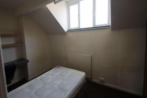 A cozy bedroom with a single bed near a window ...