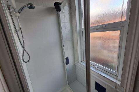 A clean and functional bathroom suite with a sh...