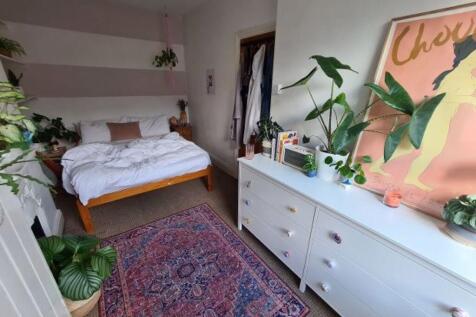 A spacious and well-lit master bedroom featurin...