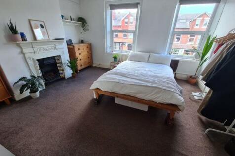 A spacious and well-lit master bedroom featurin...