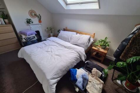 A well-lit, spacious double bedroom with a cozy...