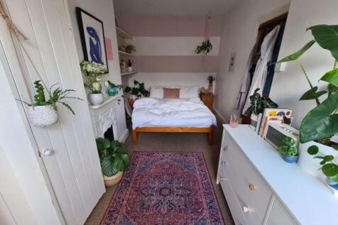 A bright and welcoming bedroom featuring a cozy...