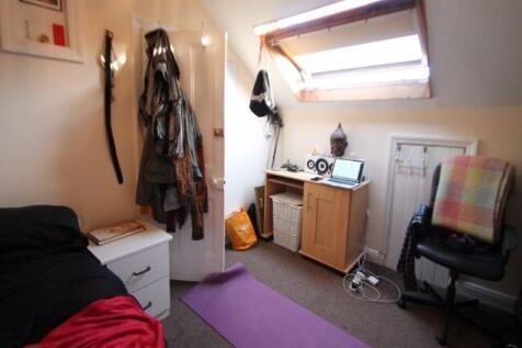 A cozy single bedroom featuring practical furni...