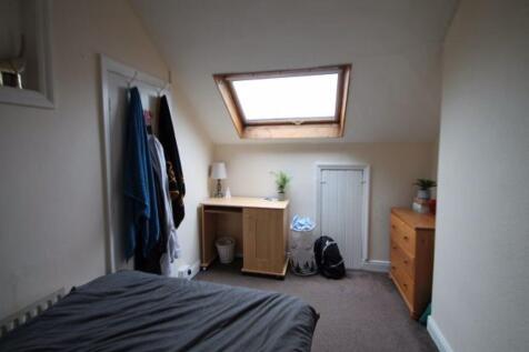 A well-lit bedroom with a skylight window, feat...