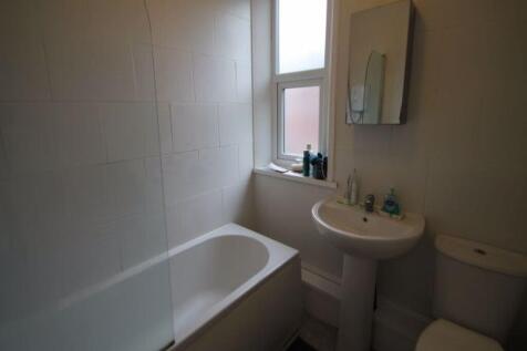 A clean, functional bathroom with a bathtub, si...