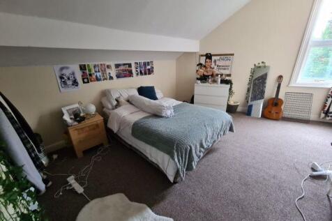 A spacious and well-lit master bedroom featurin...