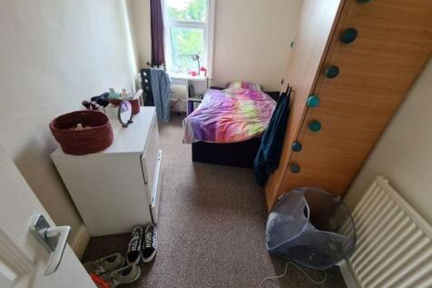 A cozy student bedroom featuring a single bed w...