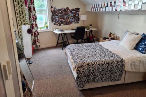 Spacious master bedroom featuring a large bed, ...