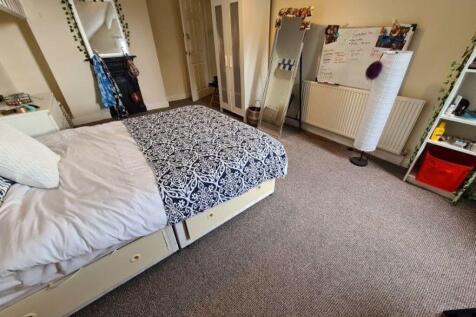 A cozy student bedroom featuring a comfortable ...