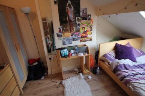 A cozy bedroom featuring a single bed with purp...