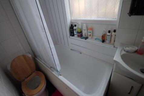A bright, clean bathroom with a bathtub, sink, ...