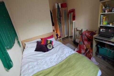 A well-lit double bedroom featuring a cozy bed ...