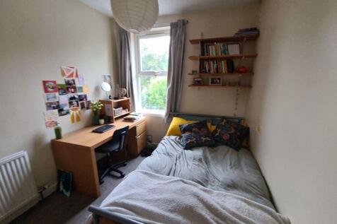 A cozy and neatly arranged bedroom with a comfo...