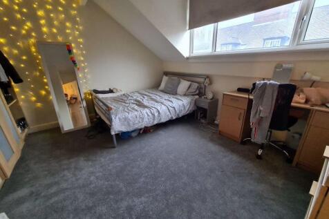 A bright and cozy bedroom featuring a comfortab...