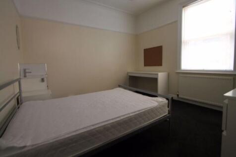 A simple and tidy bedroom featuring a comfortab...