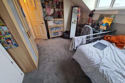 A cozy bedroom with a bed, some storage units, ...