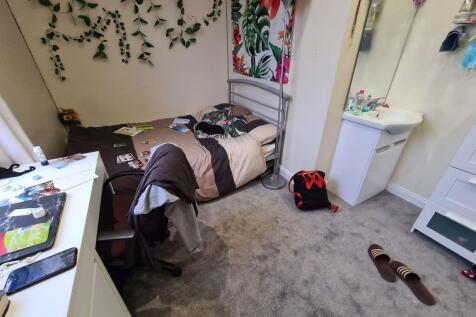 A cozy single bedroom featuring a bed and perso...