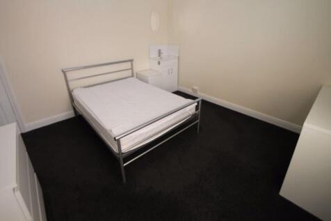 A spacious master bedroom with a comfortable do...