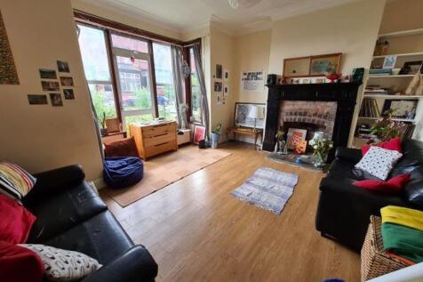 A spacious and well-lit living room featuring c...