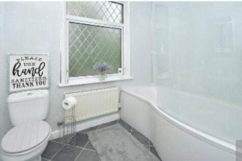 Bright and clean bathroom featuring a bathtub, ...