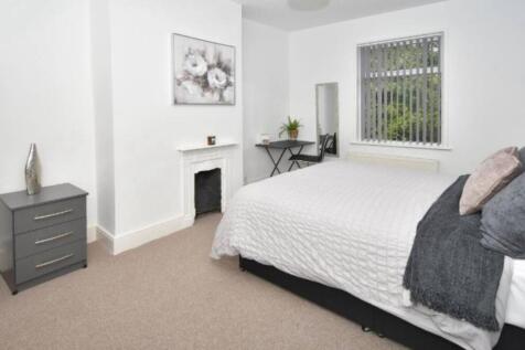 A bright, clean double bedroom featuring a comf...