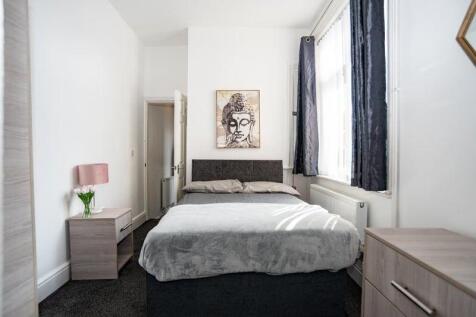 A bright and tidy double bedroom with a large b...