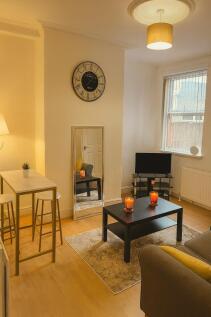A cozy and well-lit living room featuring a com...