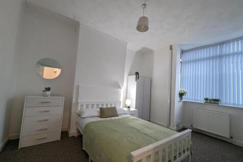 A bright and tidy bedroom with a comfortable do...