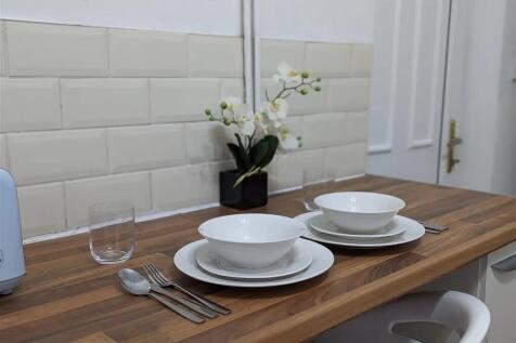 A modern, clean kitchen area with neatly arrang...