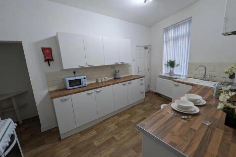 Bright and modern kitchen featuring white cabin...