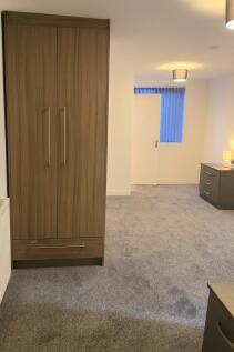 Bright, freshly carpeted bedroom with modern fi...