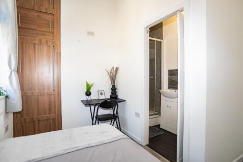 A clean and modern bathroom with a shower, smal...