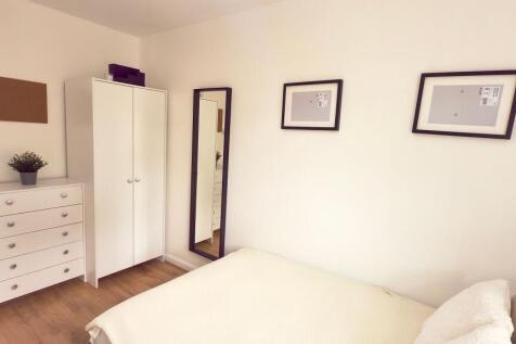 Bright and tidy bedroom featuring a comfortable...