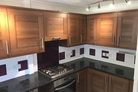 A modern kitchen featuring wooden cabinets, a s...