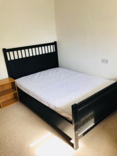 A spacious and tidy double bedroom featuring a ...