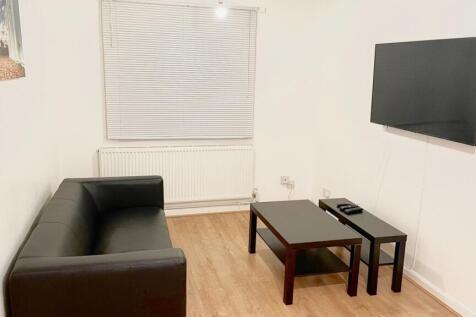 A cozy living room featuring a sleek black sofa...