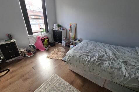 A cozy and bright bedroom with a single bed, wo...