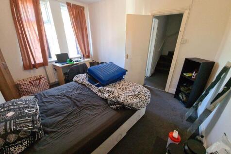 A well-lit bedroom with a double bed, providing...