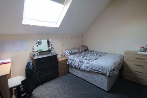 A cozy bedroom with a single bed, fitted wardro...