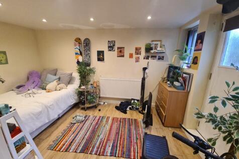 A well-lit, cozy living room with comfortable s...