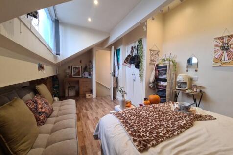 A bright, well-lit bedroom featuring a comforta...