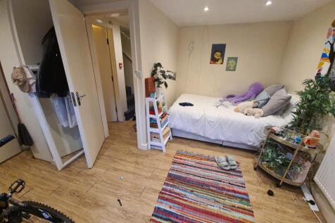 A bright and cozy bedroom featuring a large bed...