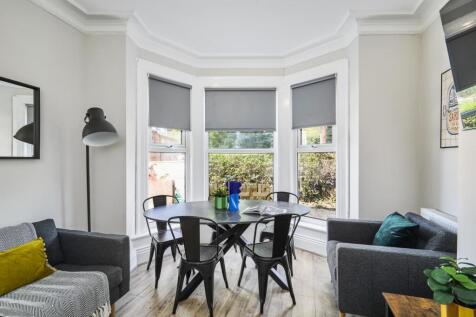 Bright and welcoming living room with large bay...