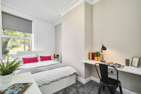 Bright and airy master bedroom with a comfortab...