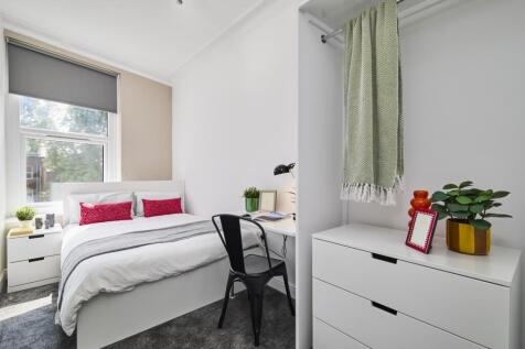 A bright and inviting bedroom featuring a large...