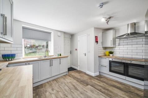 Modern and bright kitchen featuring white cabin...