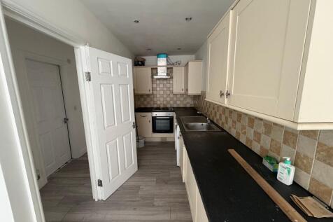 A functional kitchen with cream cabinetry and a...